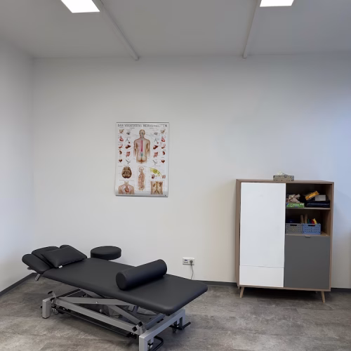 Behandlungsraum für motorisch-funktionelle Behandlung in der Ergotherapie Rheine – Therapieliege und anatomische Schautafel in der Therapiepraxis Wittenburg