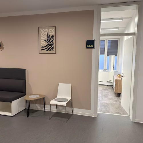 Gemütliche Sitzecke im Wartebereich der Therapiepraxis Wittenburg in Rheine mit Blick in den hellen Behandlungsraum